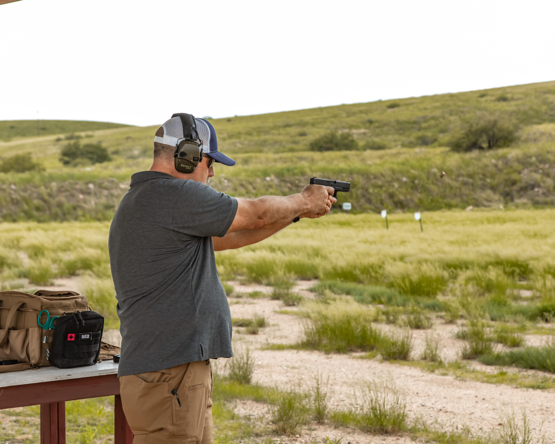 Instructor demonstrating a two-handed pistol stance on the range
