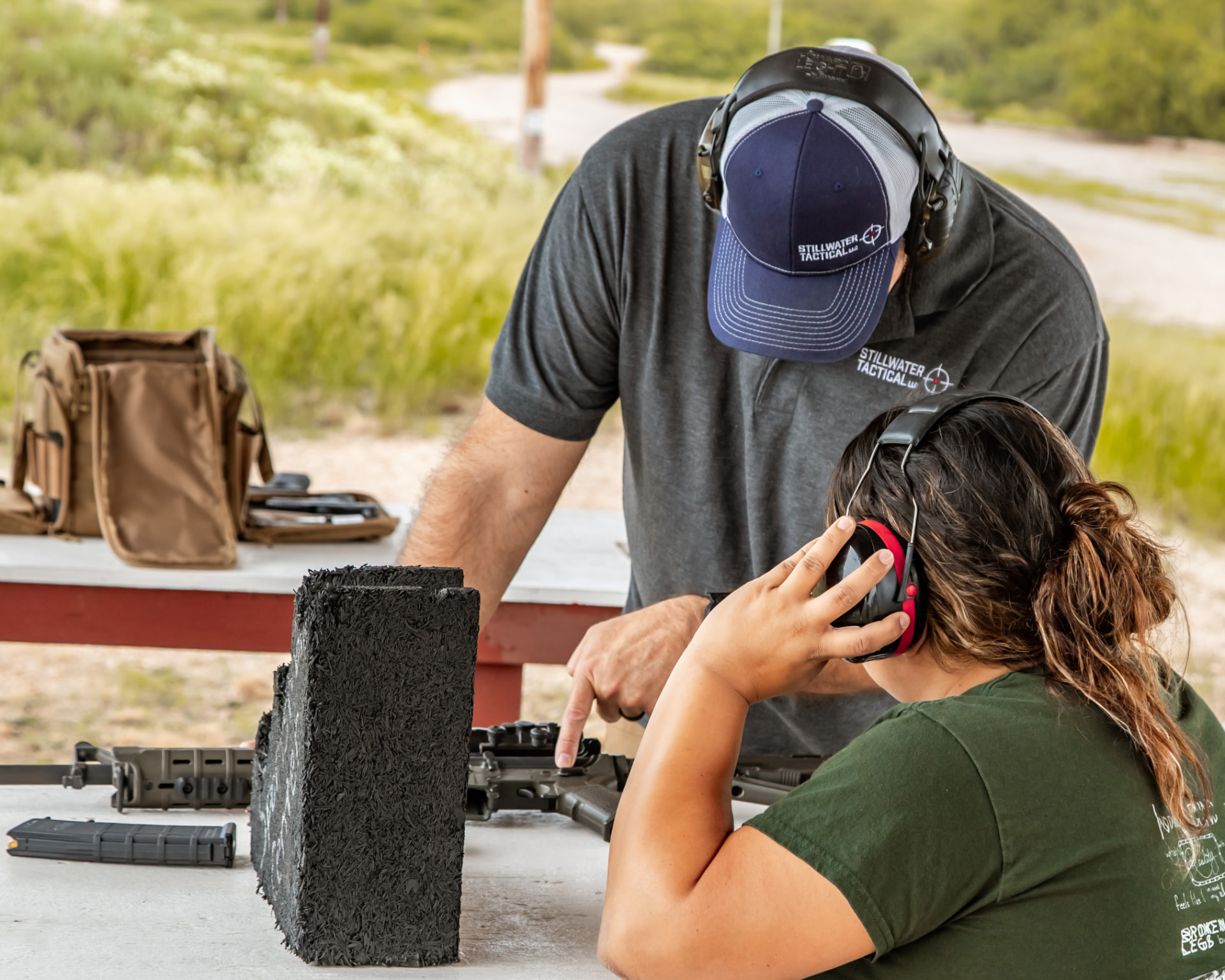 Instructor coaching a new shooter through rifle setup and safety